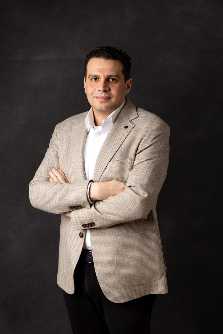 Mohamed Talaye, standing, dark background